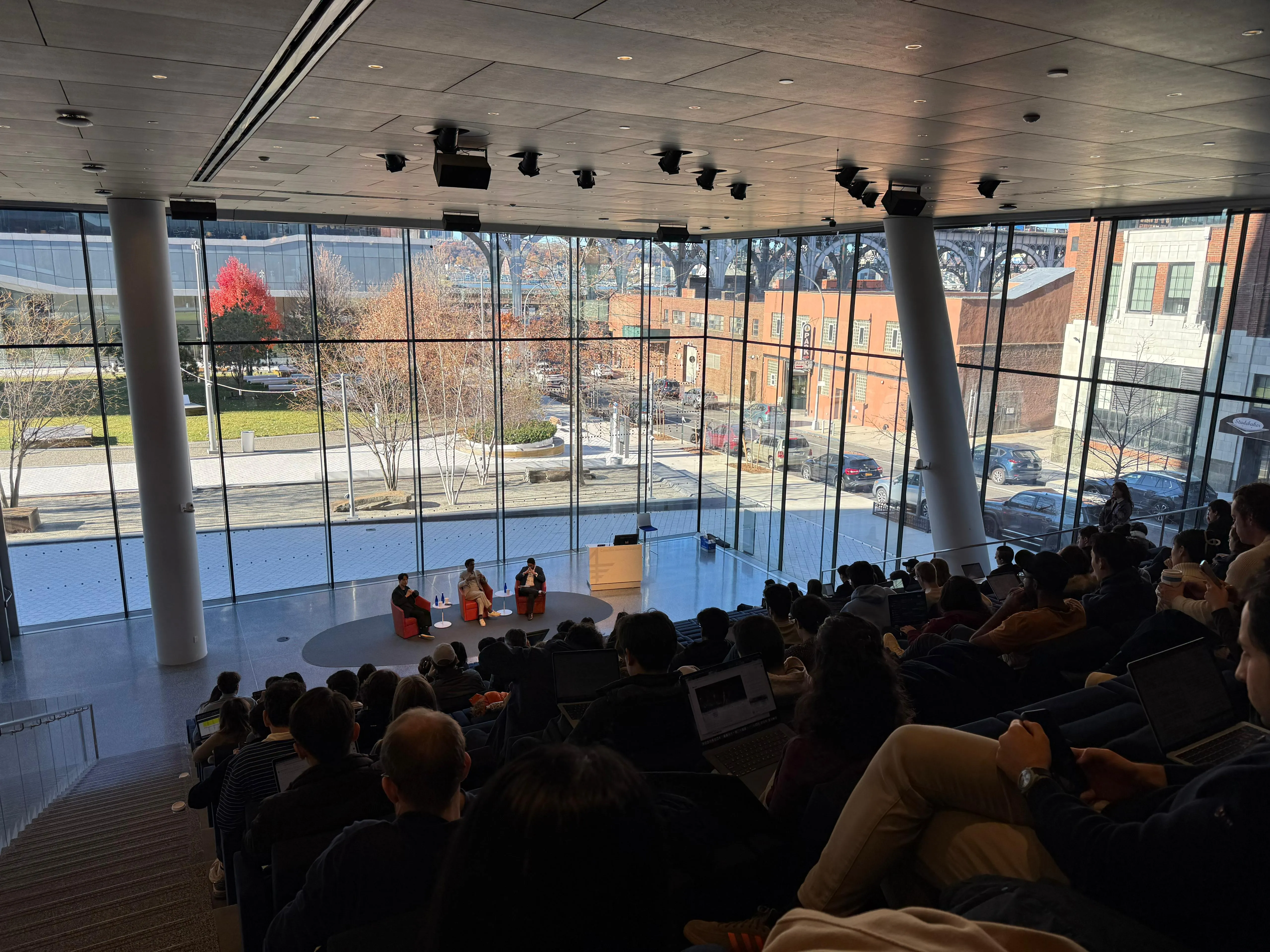 Moderating a fireside chat with a global bank CTO on stage in a glass-walled hall